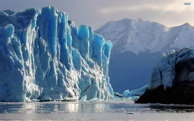 Large glacier surrounded by snow-covered mountains